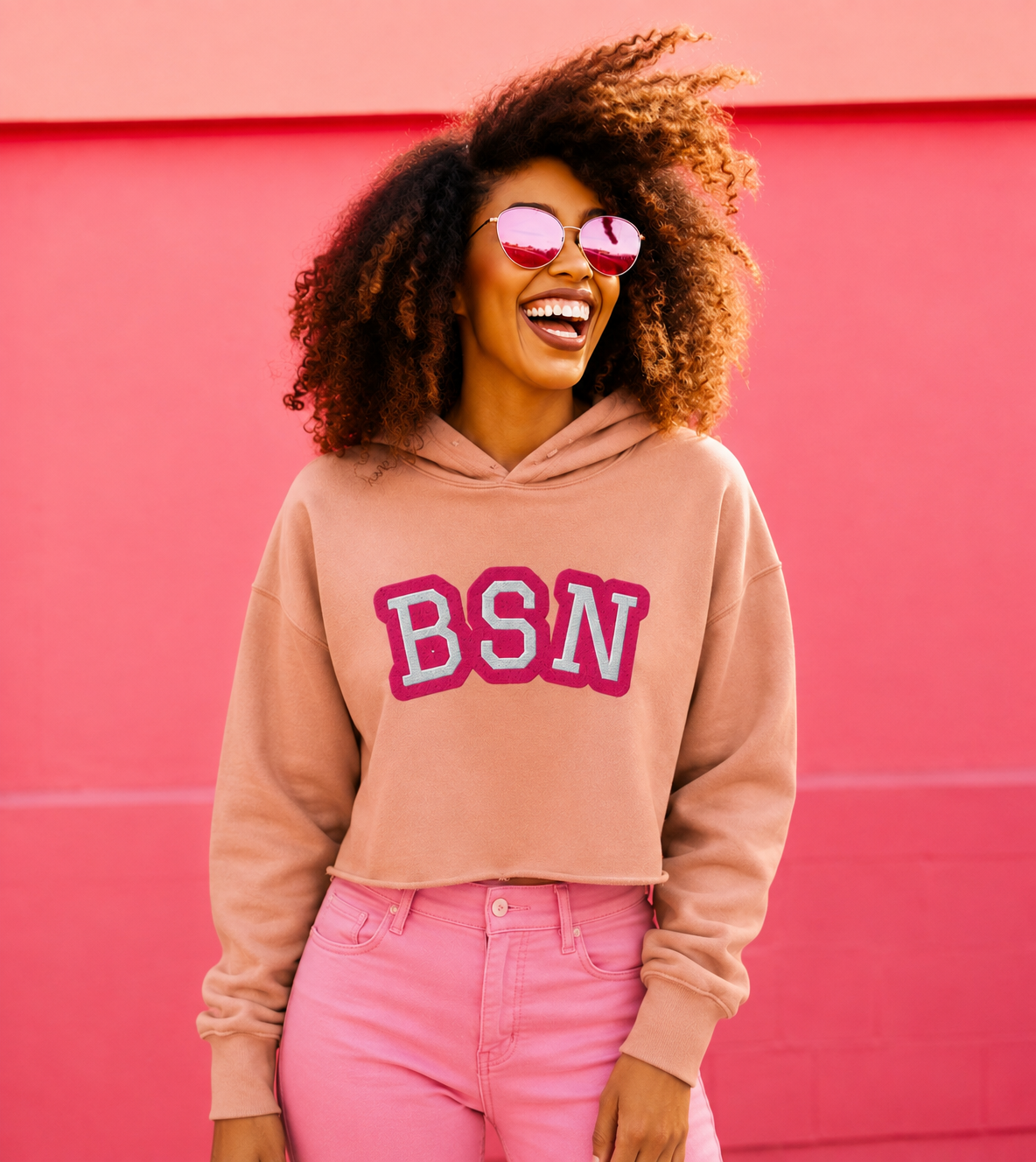 Woman wearing a peach BSN cropped hoodie