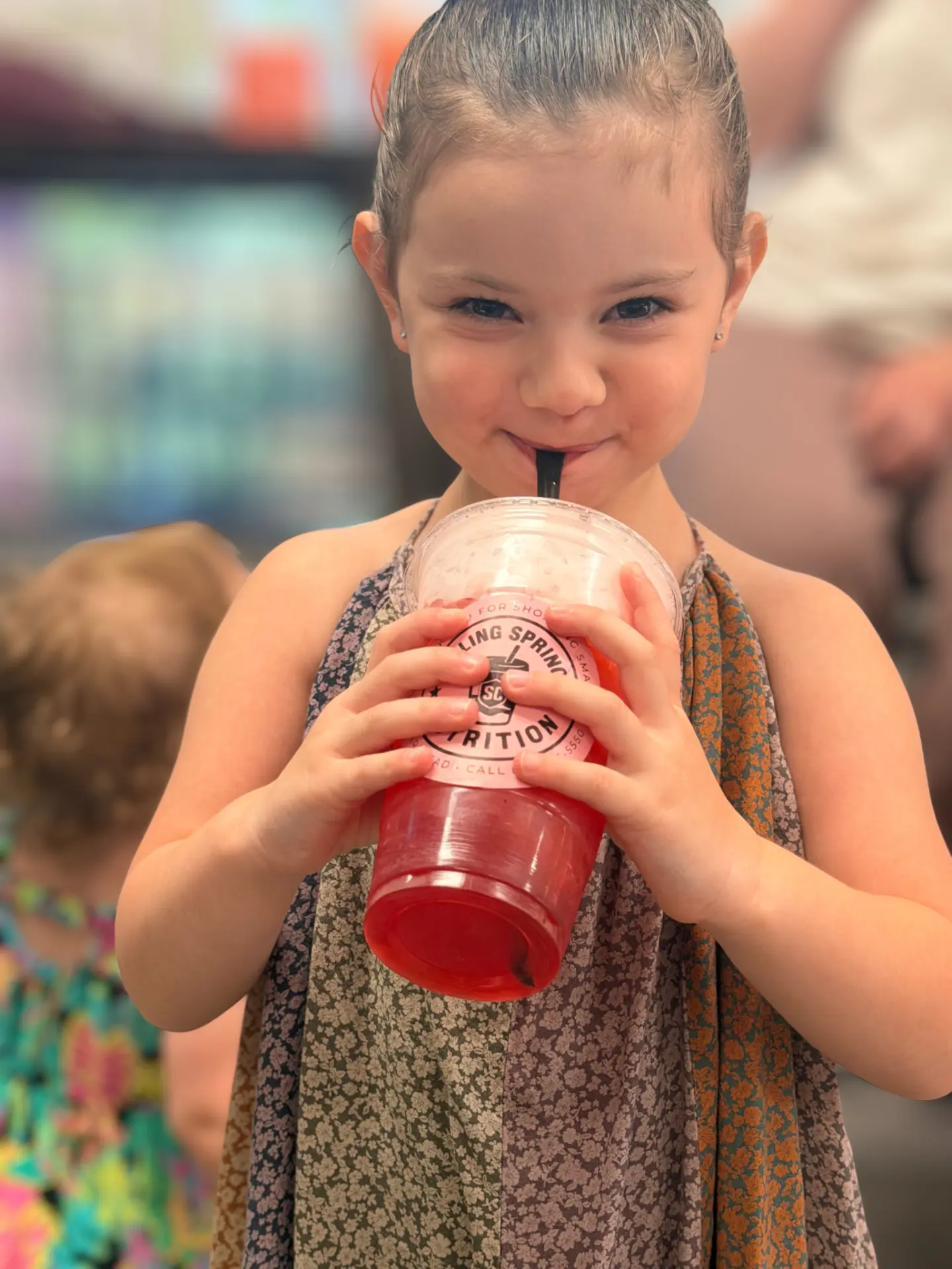 A young BSN customer enjoying a colorful BSN drink inside the shop